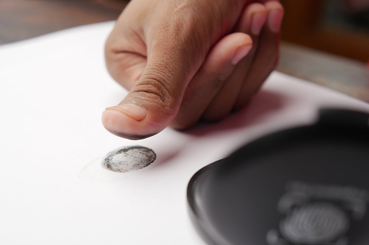 A Person Putting a Fingerprint on a White Paper